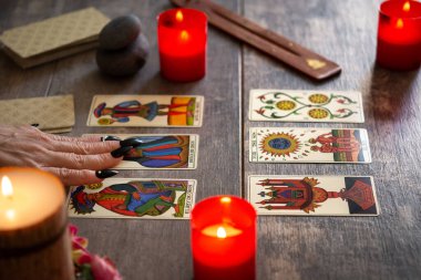 Falcı köy masasında tarot kartlarıyla geleceği okuyor.