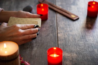 Falcı köy masasında tarot kartlarıyla geleceği okuyor.