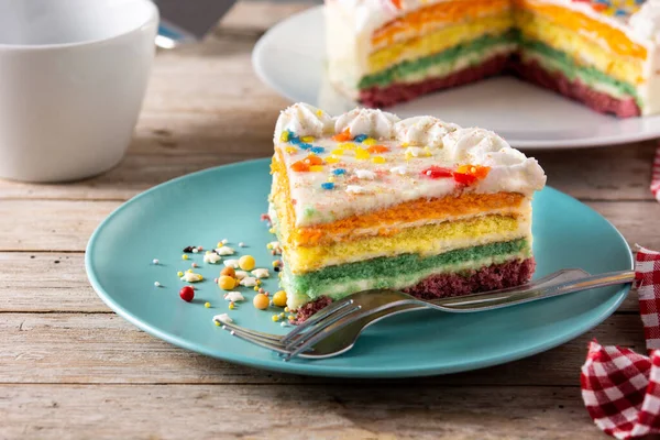 Kuchenstück Mit Regenbogenschicht Auf Holztisch — Stockfoto