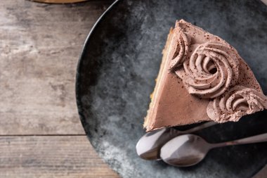 Bir parça çikolatalı mantarlı kek, ahşap masada.