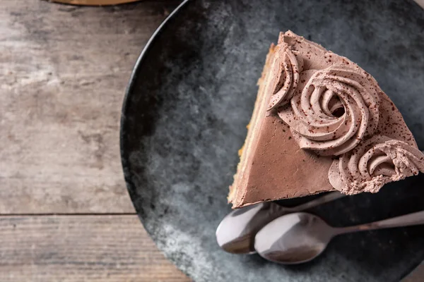 Bir parça çikolatalı mantarlı kek, ahşap masada.