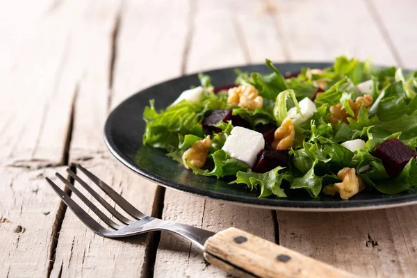 Beyaz peynirli pancar salatası, marul ve ceviz kırsal ahşap masada.