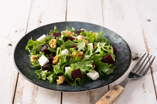 Beyaz peynirli pancar salatası, marul ve ceviz kırsal ahşap masada.
