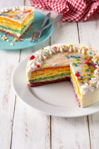 Kuchen Mit Regenbogenschicht Auf Weißem Holztisch — Stockfoto