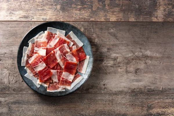Spaanse Serrano Ham Plakjes Zwarte Plaat Houten Tafel Kopieerruimte — Stockfoto