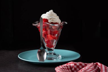 Çilek ve krem şanti siyah arka planda dondurma bardağında