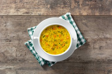 Tavuklu şehriye çorbası, beyaz kâse ve ahşap masa.