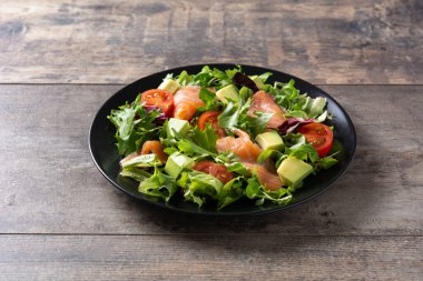 Ahşap masada somon ve avokado salatası
