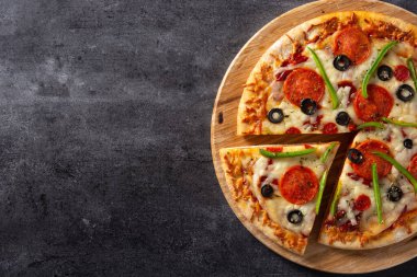 Geleneksel süper pizza, siyah taşın üzerinde. Boşluğu kopyala