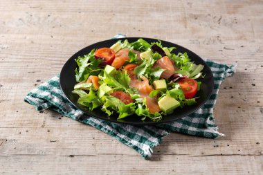 Köy ahşap masada somon ve avokado salatası.
