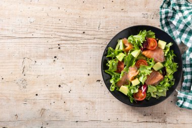 Köy ahşap masada somon ve avokado salatası. Üst Manzara. Boşluğu kopyala