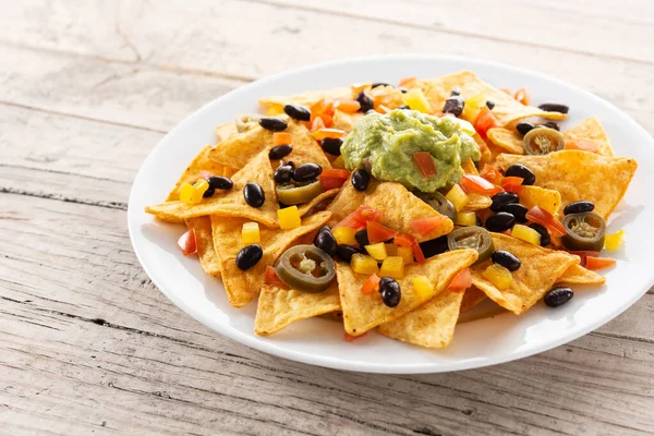 Mexické Nachos Tortilla Chipsy Černými Fazolemi Guacamole Rajčaty Jalapeno Dřevěném — Stock fotografie