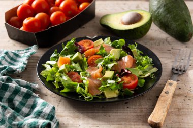 Köy ahşap masada somon ve avokado salatası.