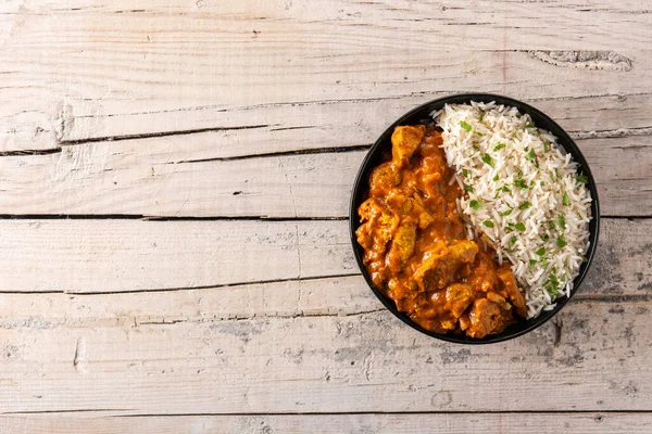 Tahta masadaki siyah kasede Hint tereyağlı tavuk. Üst Manzara. Boşluğu kopyala