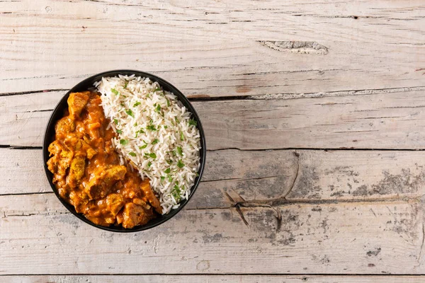 Tahta masadaki siyah kasede Hint tereyağlı tavuk. Üst Manzara. Boşluğu kopyala