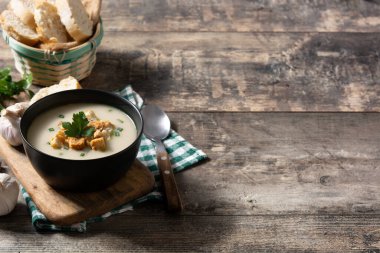Tahta masadaki kızarmış ekmeklerle sarımsak çorbası. Boşluğu kopyala.