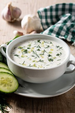 Bulgar taratör, tahta masada kasede ekşi süt çorbası içiyor