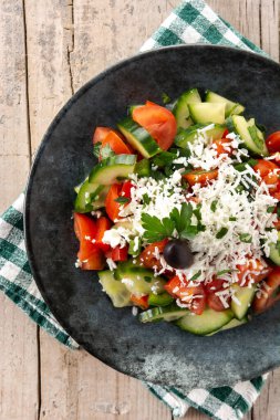 Geleneksel Bulgar salatası domates, salatalık ve İspanyol sirene peyniri ahşap masada.