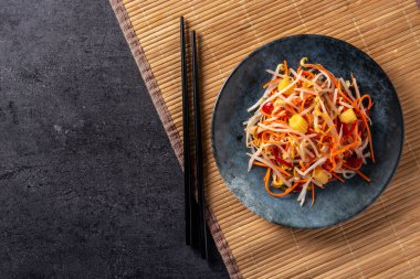 Sağlıklı Çin lahana salatası. Siyah arka planda, tabakta. Üst manzara. Boşluğu kopyala