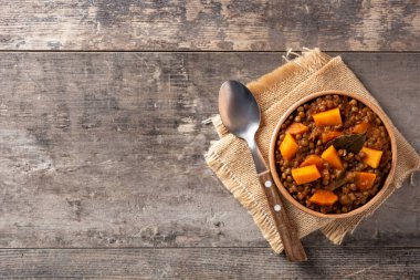 Balkabaklı mercimek yahnisi ve tahta masada havuç. Üst Manzara. Boşluğu kopyala