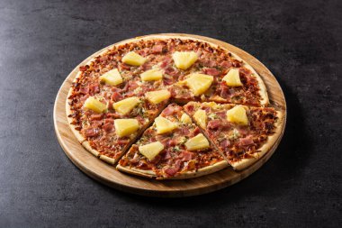 Siyah arka planda ananas, jambon ve peynirli Hawaii pizzası.