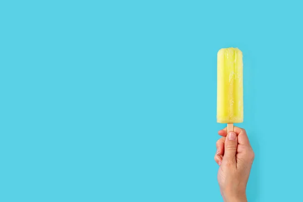 Die Hand Hält Ein Zitroneneis Auf Blauem Hintergrund Kopierraum — Stockfoto