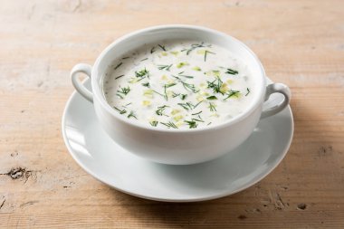 Bulgar taratör, tahta masada kasede ekşi süt çorbası içiyor