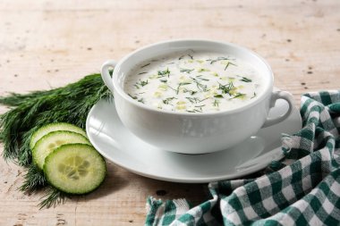 Bulgar taratör, tahta masada kasede ekşi süt çorbası içiyor