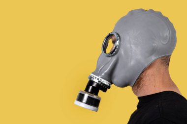 Sarı arka planda gaz maskeli bir adam. Boşluğu kopyala