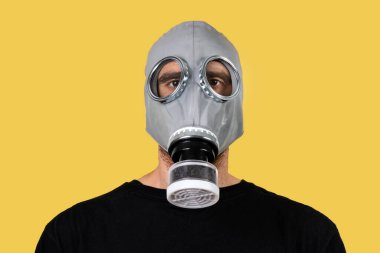 Sarı arka planda gaz maskeli bir adam.