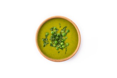 Beyaz arka planda izole edilmiş bir kasede yeşil bezelye çorbası
