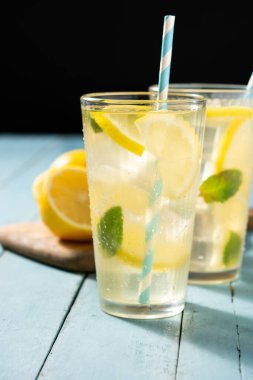 Mavi ahşap masada bir bardak taze limonata.