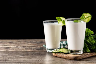 Ayran nane şekeri ve ahşap masadaki salatalıkla içer. Boşluğu kopyala