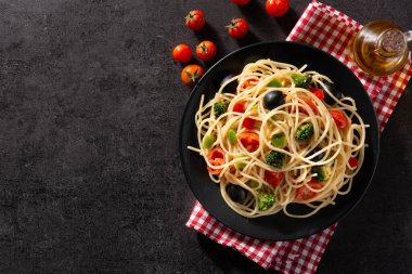Siyah arka planda sebzeli spagetti (brokoli, domates, biber). Üst Manzara. Boşluğu kopyala