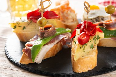 Ahşap masada İspanyol pintxos çeşitleri. Tipik İspanyol yemekleri.