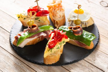 Ahşap masada İspanyol pintxos çeşitleri. Tipik İspanyol yemekleri.