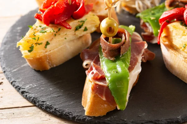 Ahşap masada İspanyol pintxos çeşitleri. Tipik İspanyol yemekleri.