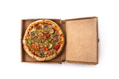 Kabaklı, domatesli, biberli ve mantarlı vejetaryen pizza beyaz arka planda izole bir şekilde paketlenmiştir.