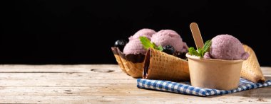 Böğürtlenli dondurma kepçeleri ahşap masada. Panorama manzaralı. Boşluğu kopyala
