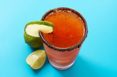 Bira, limon suyu, acı sos, tuzlu jant ve domates suyuyla ev yapımı michelada kokteyli.