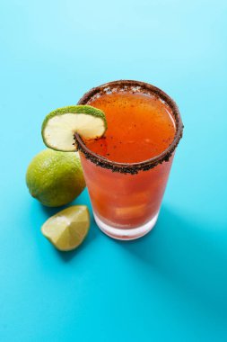 Bira, limon suyu, acı sos, tuzlu jant ve domates suyuyla ev yapımı michelada kokteyli.