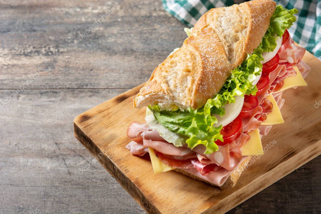 Sandwich submarino con jamón, queso, lechuga, tomate, cebolla