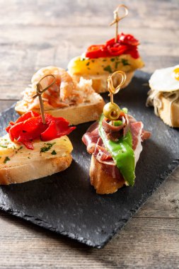 Ahşap masada İspanyol pintxos çeşitleri