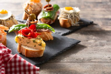 Ahşap masada İspanyol pintxos çeşitleri. Boşluğu kopyala