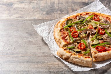 Tahta masada kabaklı, domatesli, biberli ve mantarlı vejetaryen pizza. Boşluğu kopyala