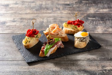 Ahşap masada İspanyol pintxos çeşitleri