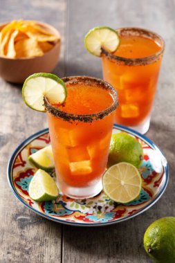 Bira, limon suyu, acı sos, tuzlu jant ve domates suyuyla ev yapımı michelada kokteyli.