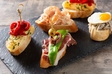 Ahşap masada İspanyol pintxos çeşitleri