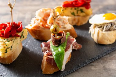 Ahşap masada İspanyol pintxos çeşitleri