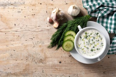 Bulgar taratör, ahşap masada kasede ekşi süt çorbası içiyor. Üst Manzara. Boşluğu kopyala